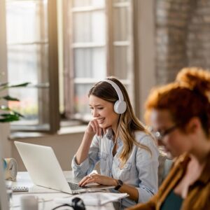 happy-female-freelancer-working-computer-while-listening-music-headphones-office_637285-1951